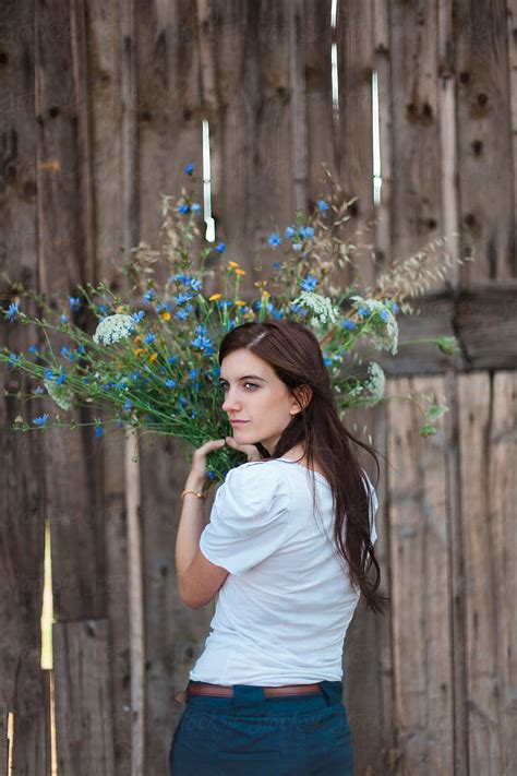 Beautiful Brunette Turns Back And Looks Away While Holding Flowers Bouquet By Laura Stolfi