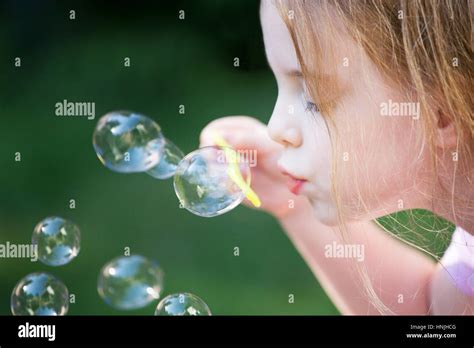 Little Girl Blowing Bubbles Outside Stock Photo Alamy