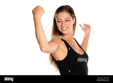 A Young Beautiful Smiling Woman In A Shirt Showing Her Biceps On A