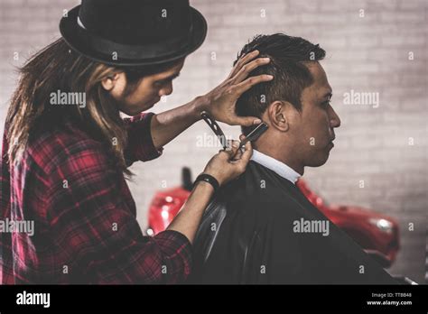 close up portrait of Asian barber with long hair shaving his costumer