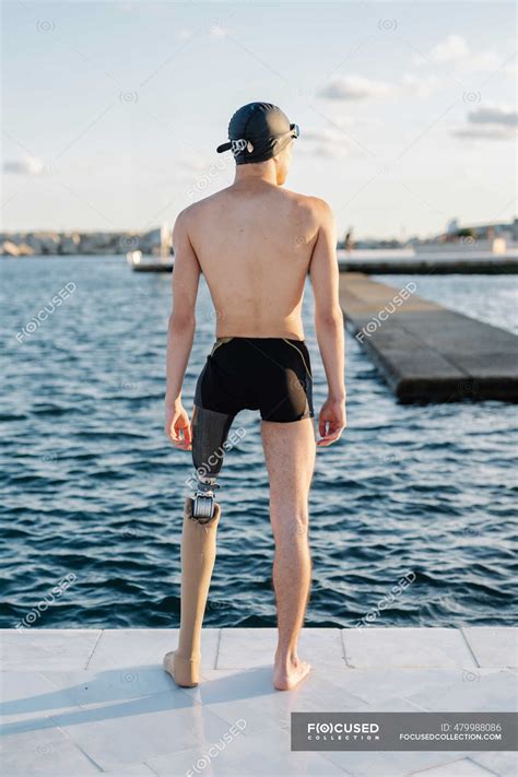 Amputee Male Looking At Sea While Standing On Promenade During Sunny