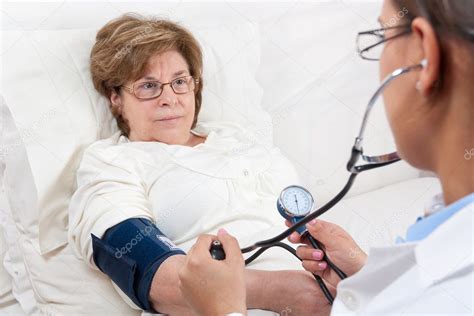 Doctor Measuring Blood Pressure On Senior Patient — Stock Photo
