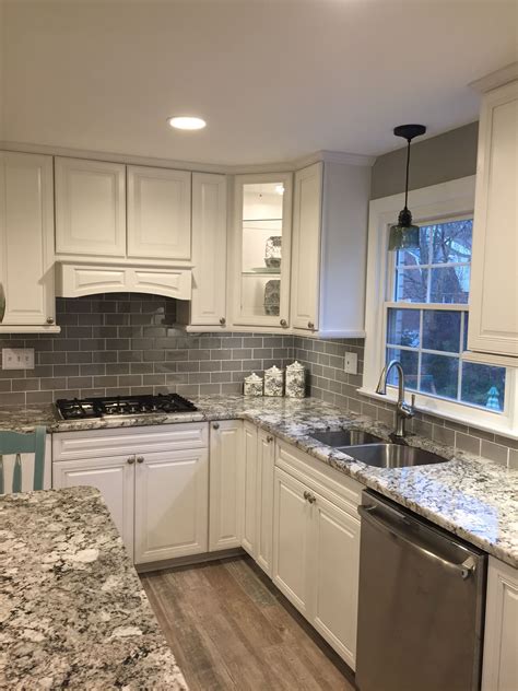 Kitchen with white cabinets and seafoam green subway tile backsplash. Stunning remodeled kitchen using Ice Gray Glass Subway Tile backsplash. https://www.subw ...