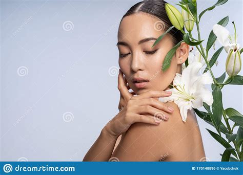 Tender Asian Lady Posing With Beautiful Bouquet In Studio Stock Photo