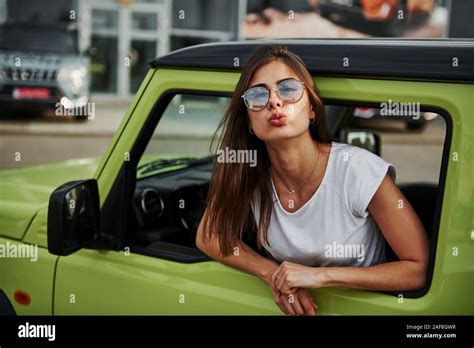 Pretty Woman In The Green Modern Car Posing For The Camera Stock Photo Alamy