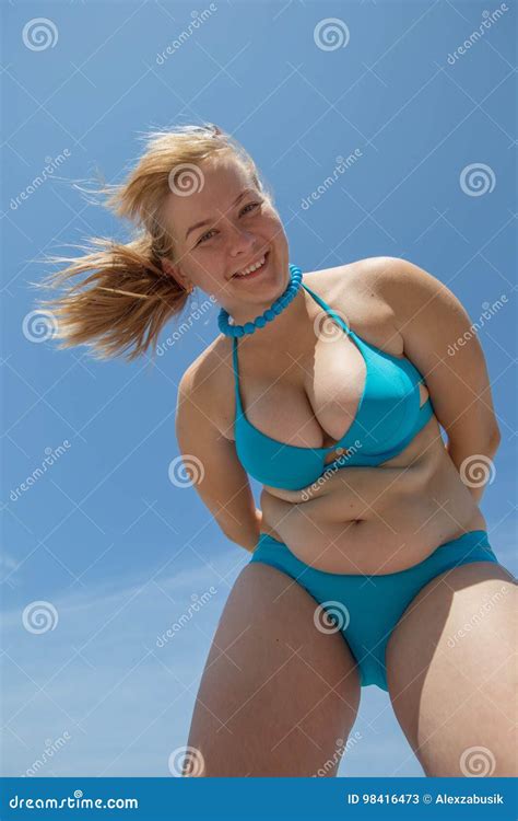 Overweight Woman Catches Fat On Her Belly On A Blue Background