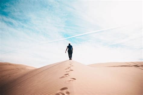 Man Walking On Desert Photo Free Desert Image On Unsplash