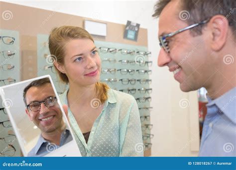 female optometrist helping patient to choose new glasses stock image image of client