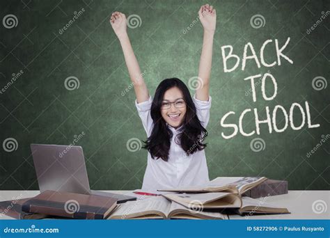 Excited Female Student Raising Hands In Classroom Stock Photo Image