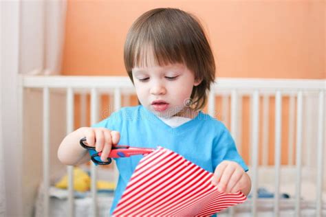 Lovely Toddler Boy With Scissors Cutting Paper At Home Stock Image