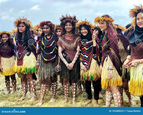 Young Girls Of A Papuan Tribe In A Beautiful Crown From Bird Feathers On Baliem Valley Festival