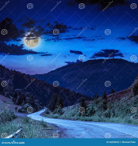 Mountain Road Near The Coniferous Forest With Cloudy Moon Sky Stock