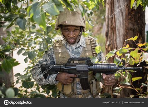 Soldat debout dans une forêt abandonnée — Photographie Wavebreakmedia ...