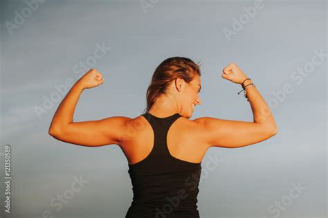 Smiling Woman Showing Strong Biceps After Outdoors Fitness Workout