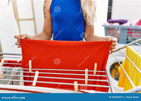 Young Woman Hanging Clothes On Clothesline At Laundry Room Stock Image