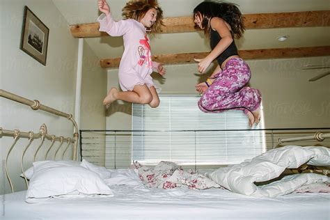 Babe Girls Jumping On Bed In Pajama By Stocksy Contributor Raymond Forbes LLC Stocksy