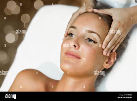 Young Blond Woman Receiving A Head Massage In A Spa Center With Blue Eyes Female Patient Is