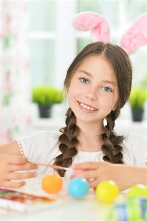 Portrait Of Cute Girl Painting Eggs For Easter Holiday Stock Photo