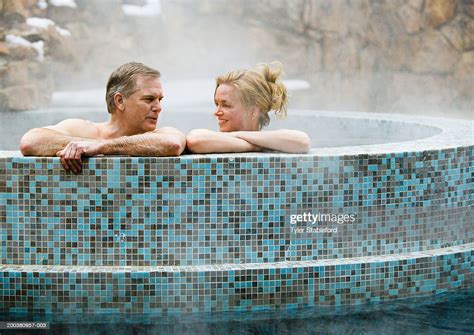 Mature Couple In Outdoor Hot Tub Looking At Each Other Side View High