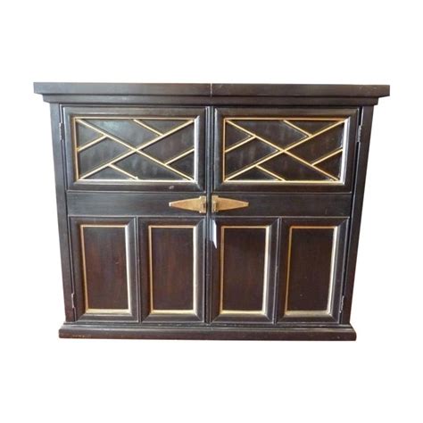 Amazing gallery of interior design and decorating ideas of glass front black and gold wet bar cabinets in dining rooms, kitchens by elite interior designers. Black and Gold Expandable Bar Cabinet | Chairish