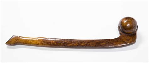 Carving out a ball club from a birch log. Native American War Club
