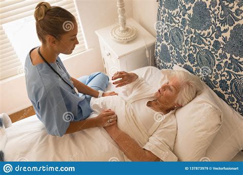 Senior Woman Interacting With Female Doctor In Bedroom Stock Image