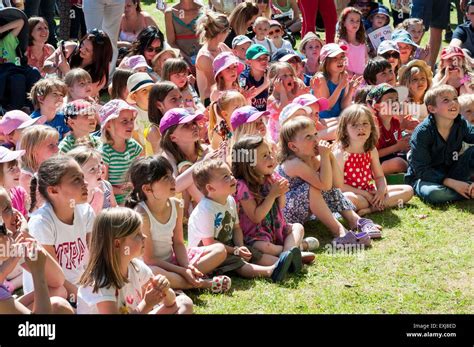 Audience Of Children Sat On The Grass In The Sunshine Watching A Punch