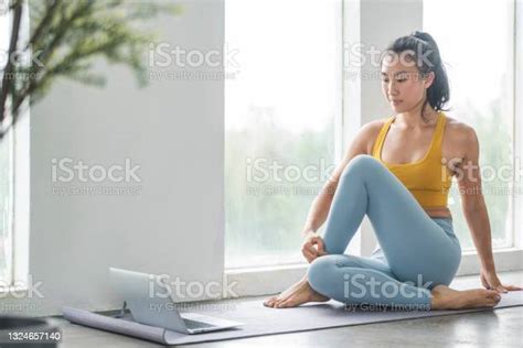 Female Asian Yoga Instructor Conducting An Online Class With Laptop
