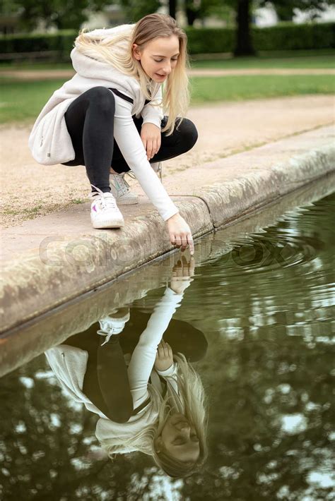 Young Girl Near A Pond With Reflection In The Water Stock Image Colourbox
