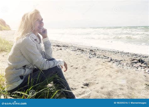 Mulher Loura Bonita Que Senta Se Na Praia Foto De Stock Imagem De