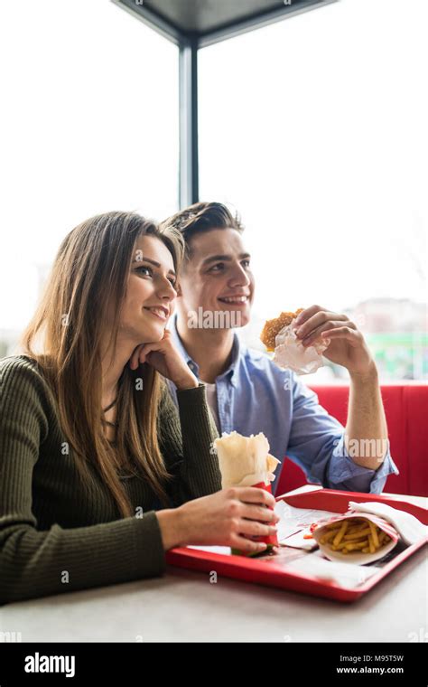 A Happy Smiling Woman And A Handsome Man Are Enjoying Their Delicious
