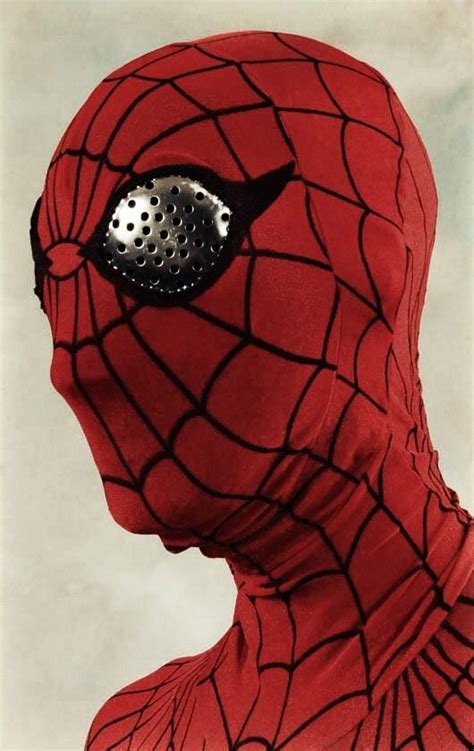 A Man In A Red Spider Suit With A Metal Eye Patch On His Face And Nose