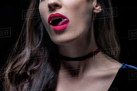Cropped View Of Sexy Vampire Woman Licking Her Lips Isolated On Black