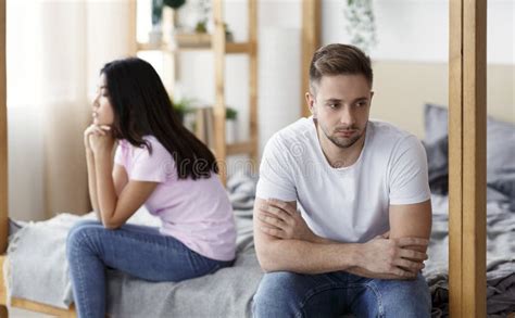 Couple After Quarrel Sitting On Different Sides Of Bed Indoor Stock