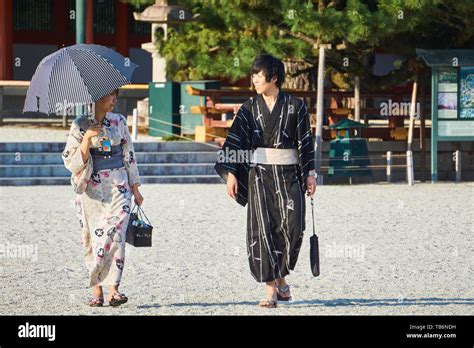 A Japanese Tourist Couple Dressed In Traditional Kimono Yukata Look At
