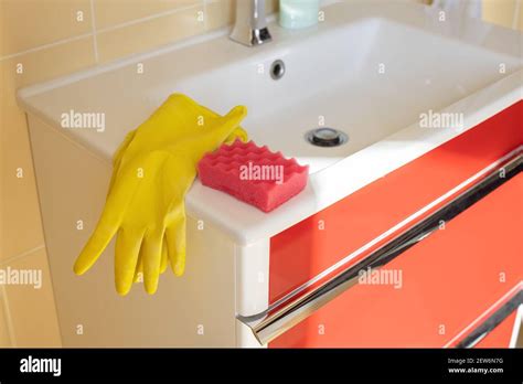 Cleaning Bathroom Sink And Faucet With Detergent In Yellow Rubber