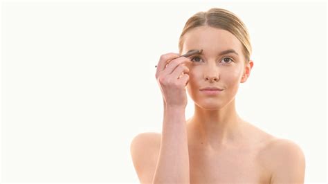 The Woman Applying Makeup On Her Face On The White Background Stock