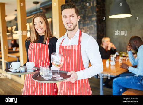 Waiter And Waitress While Serving Together In The Bistro Or Restaurant