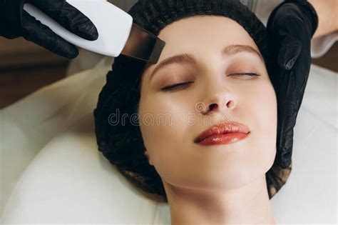 Young Woman Having Machine Cosmetology Procedure For Face Rejuvenation In Beauty Salon
