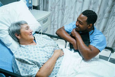 Nurse Talking To Patient In Hospital Bed Stock Photo Dissolve