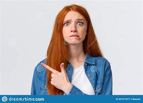 anxious and worried concerned redhead caucasian girl having big problems nervously biting lip
