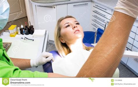 Closeup Portrait Of Beautiful Blonde Woman Lying In Dentist Chair At