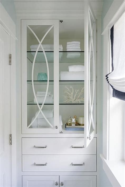 This bathroom storage cabinet boasts the understated molding, recessed panels, angled apron and tapered feet that characterize the manor grove collection. Like a storage cabinet for master. Like Glass doors and ...
