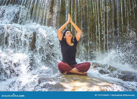 Young Beautiful Women Doing Yoga Sitting Pose At Waterfall Stock Photo