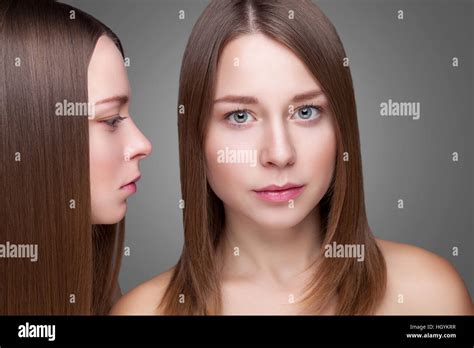 Portrait Of Twins With Perfect Skin And Long Straight Hair Stock Photo