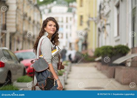 Pretty Young Tourist Woman In Casual Clothes On A Sidewalk Of The