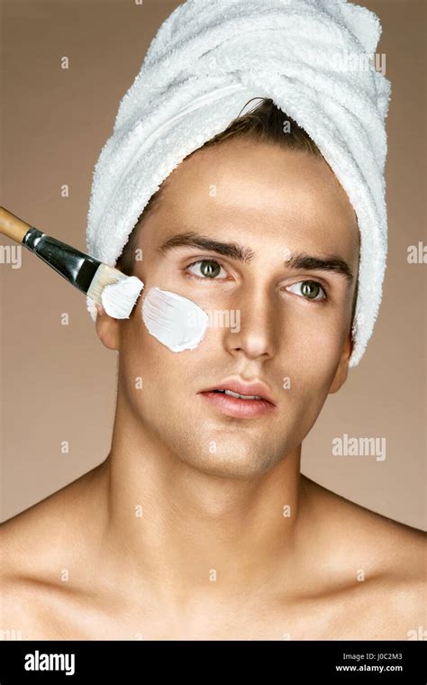 Beautician Is Applying Facial Cream On His Skin Fashionable Man