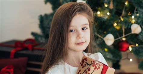 Girl With Long Hair Wearing White Dress Holding A Christmas Present