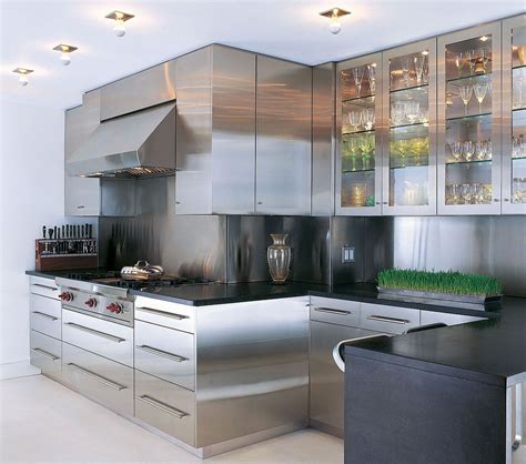 A Modern Kitchen With Stainless Steel Cabinets And Black Counter Tops