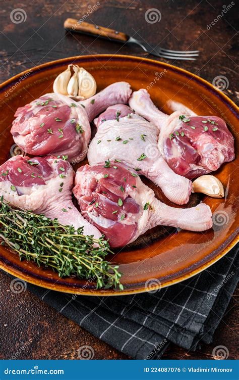 Raw Poultry Meat Duck Legs Drumsticks On A Rustic Plate With Herbs Dark Background Stock